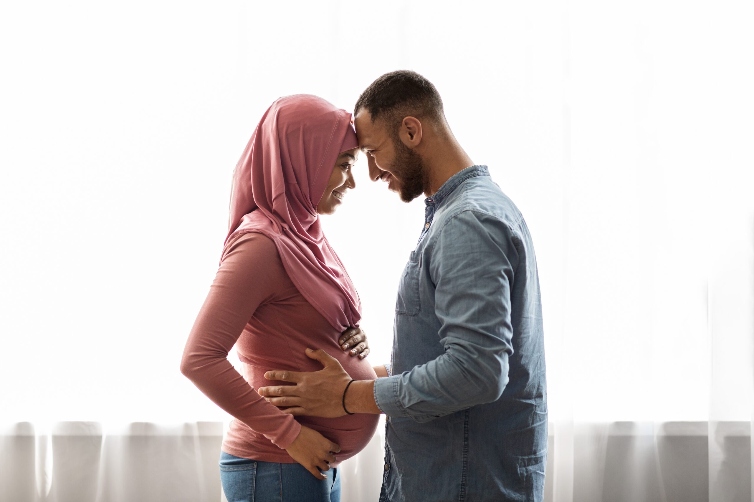 Pregnant,Black,Muslim,Woman,And,Her,Happy,Husband,Hugging,Near