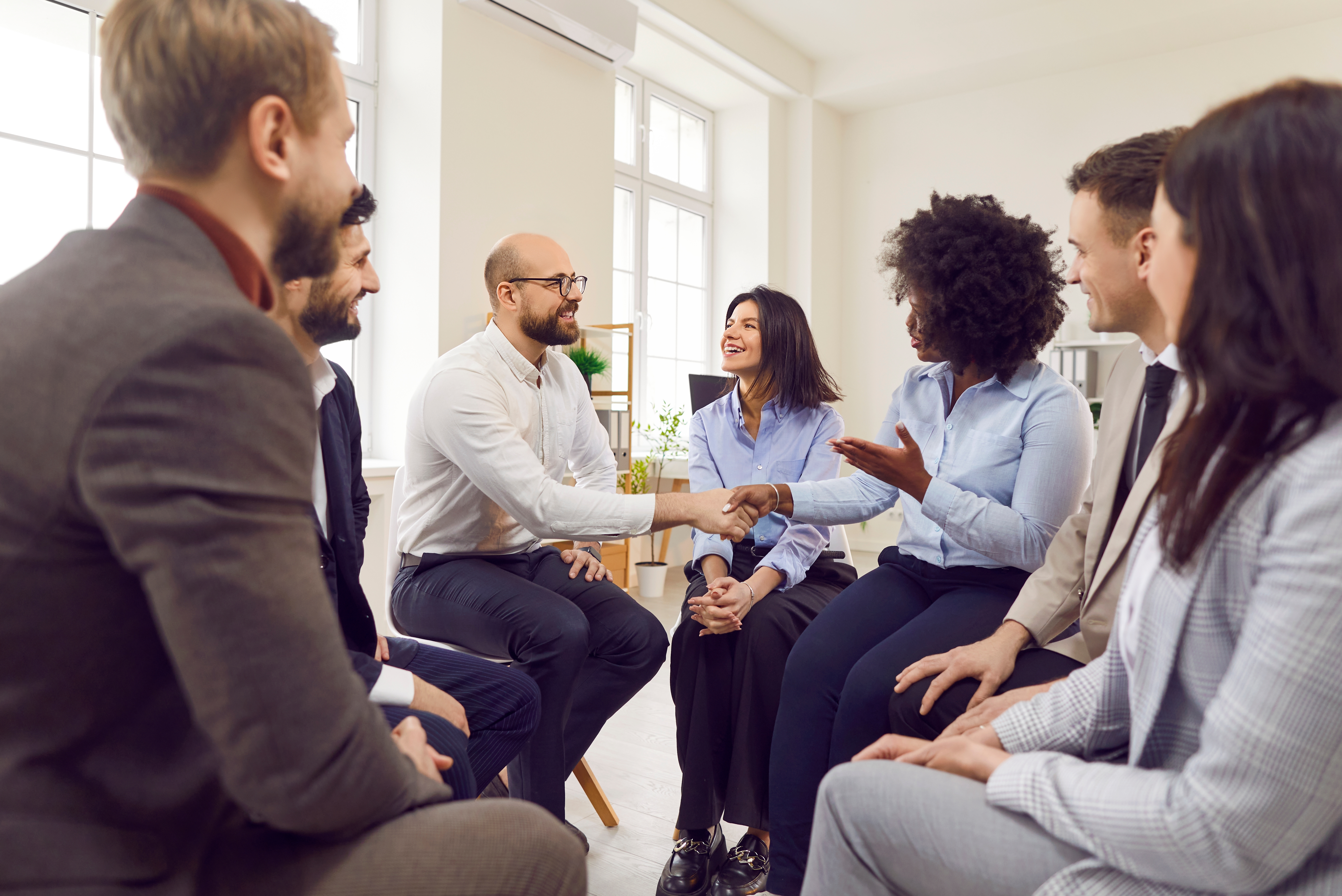 Multicultural,Group,Of,Business,People,Sitting,On,Chairs,In,A